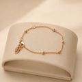 Gold bead anklet on a cream display stand