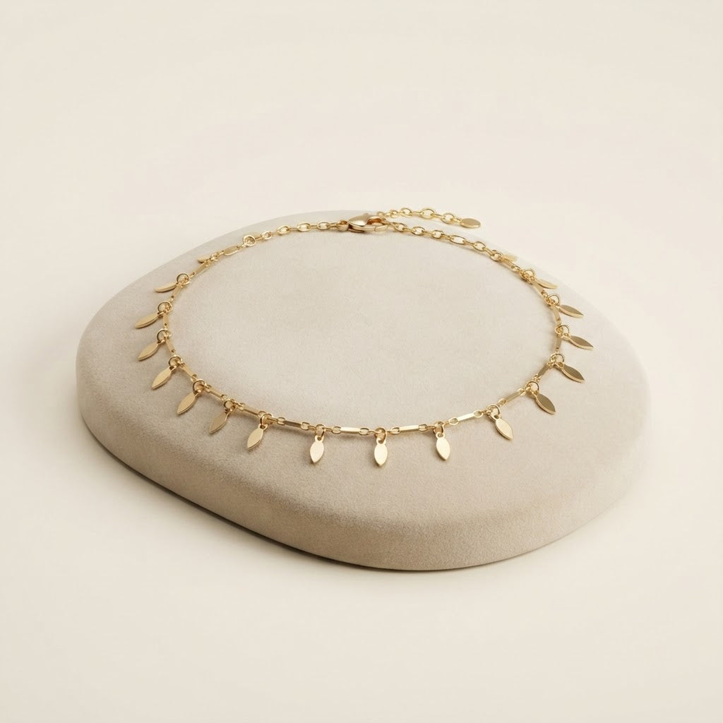 Gold leaf charm anklet on a cream display stand