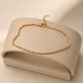 Gold rope chain anklet on a cream display stand